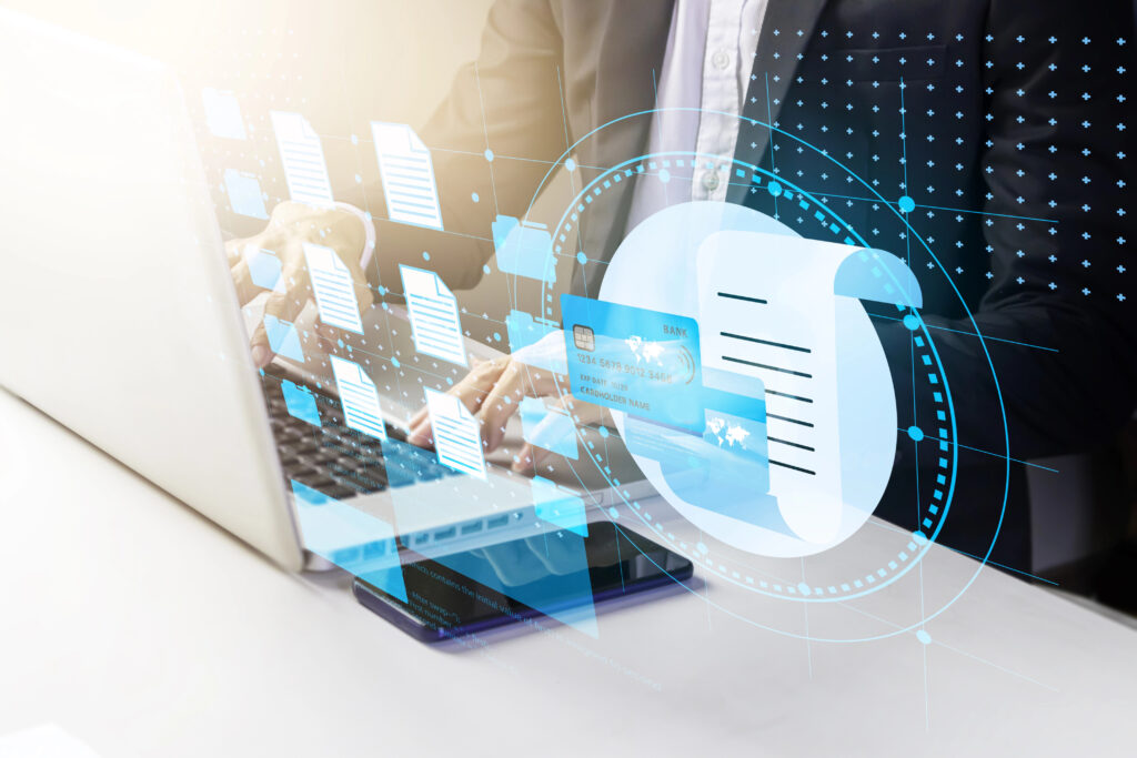 Businessman typing on a laptop with infographics of files popping out of the screen.